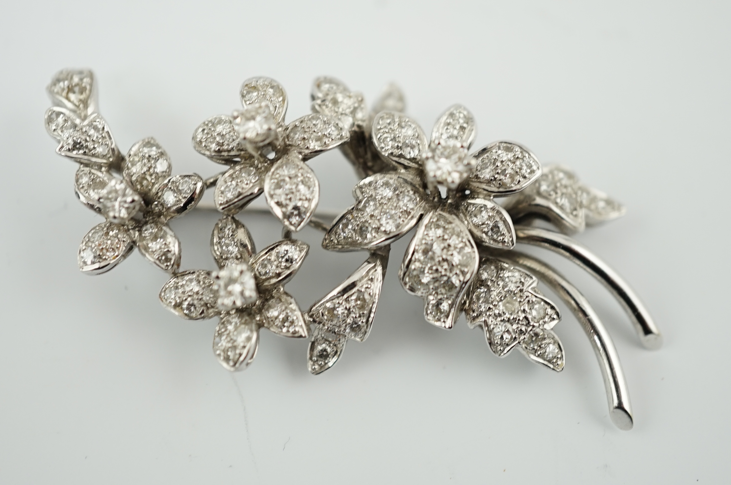 A late 1960's 18ct white gold and diamond cluster set floral spray brooch